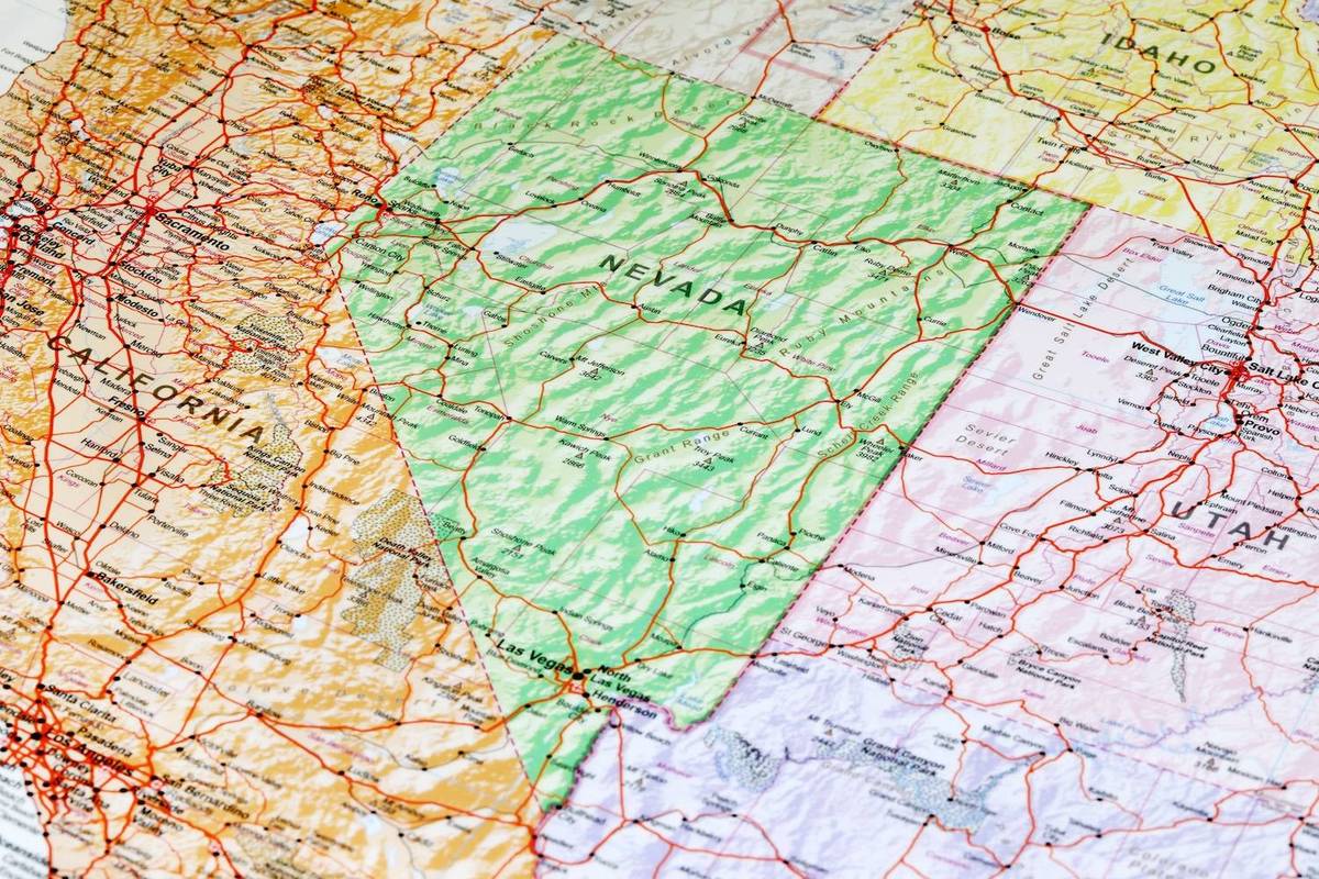 A colorful map showing Nevada in green bordered by California, Idaho, and Utah, with roads and cities marked.