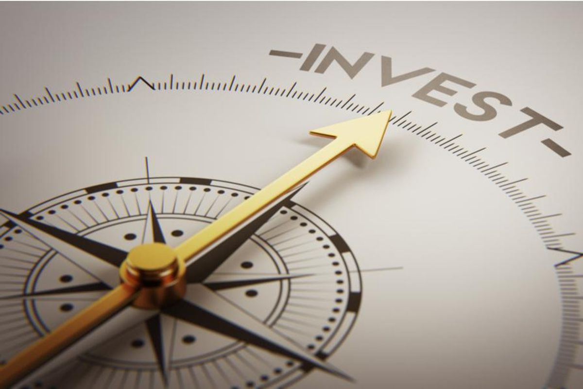 a compass pointing towards the word "invest"