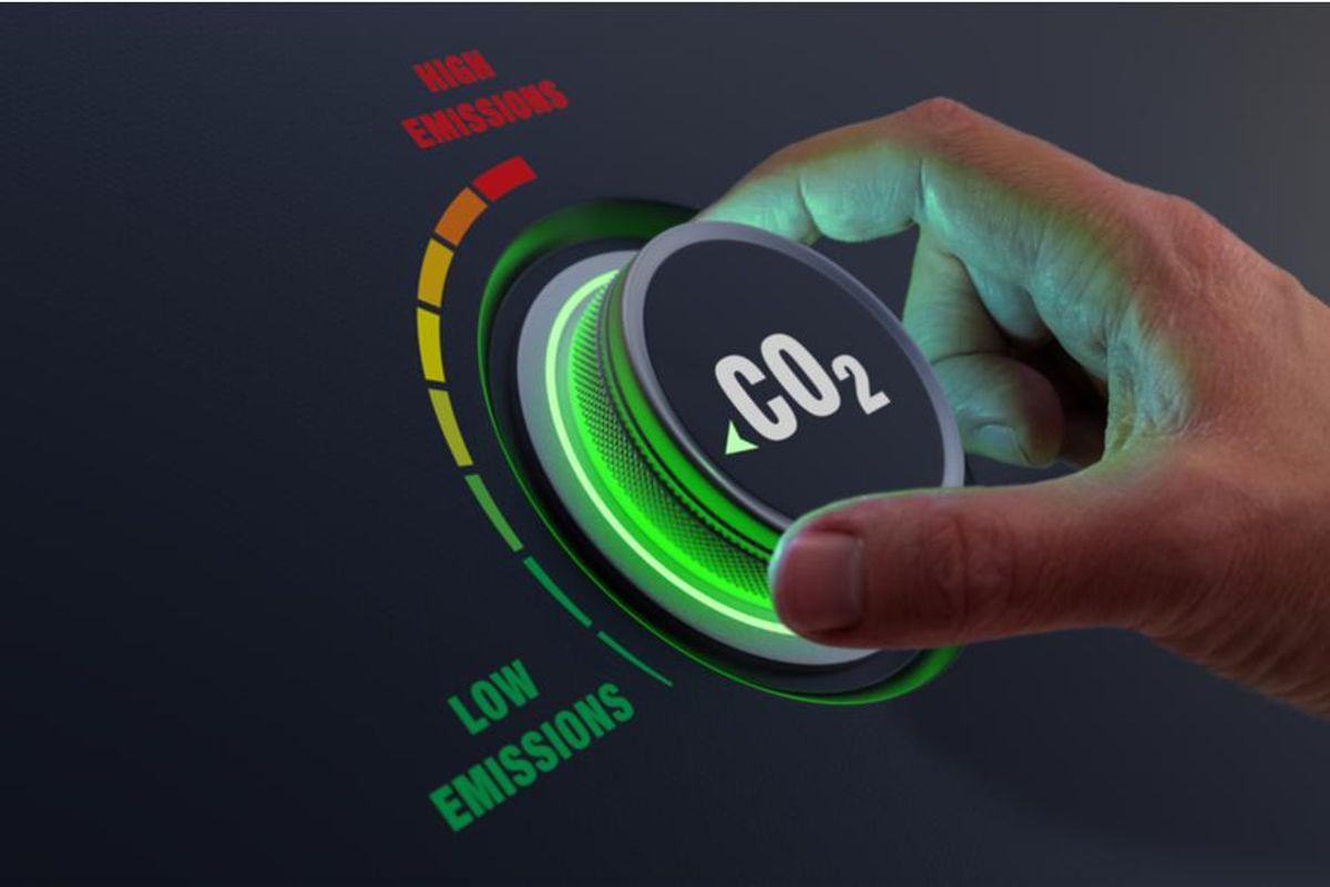 a dial displaying CO2 and a hand twisting it towards "low emissions"