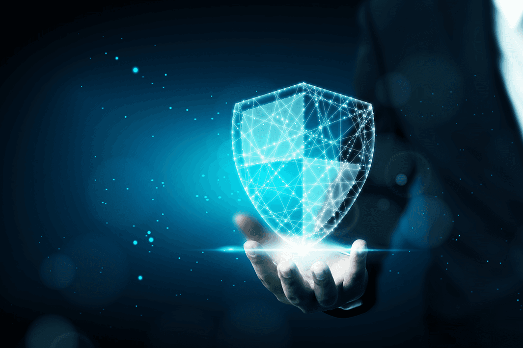 A glowing, digital shield hovers over a hand in a dark suit against a blue, starry background.