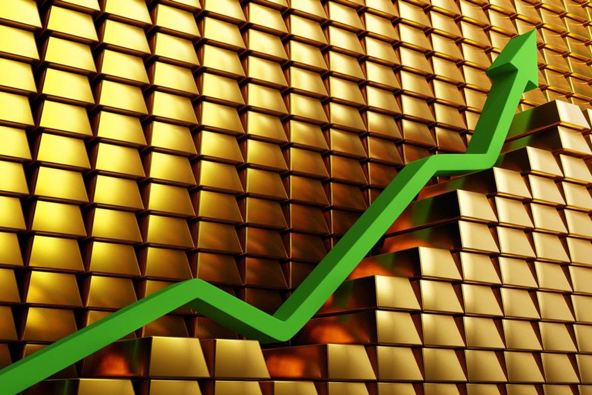 a green arrow ascending in front of gold bars