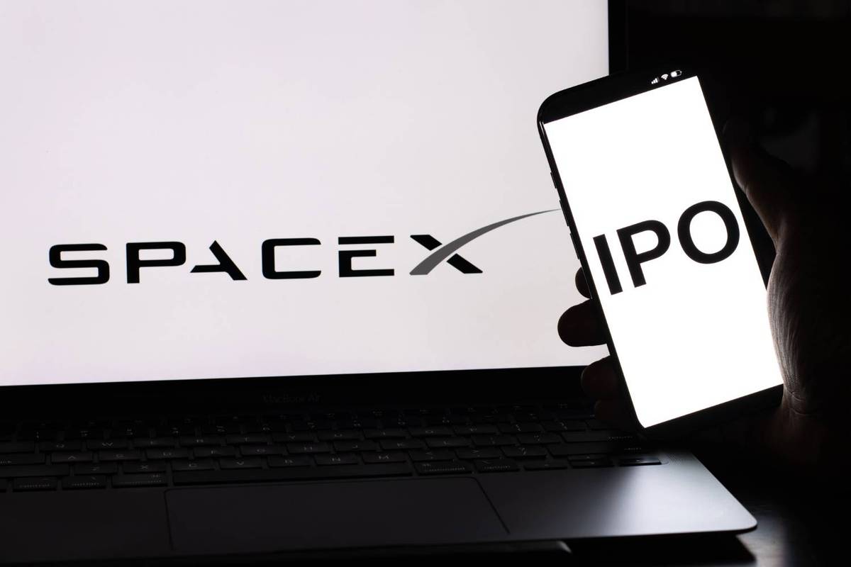 A laptop displays "SpaceX" while a phone shows "IPO."