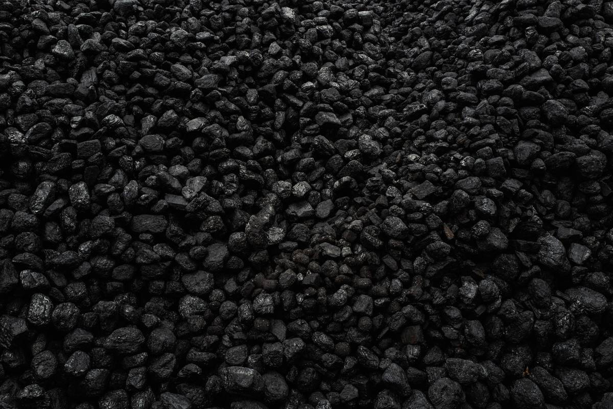 A large pile of dark black coal pieces tightly packed together.