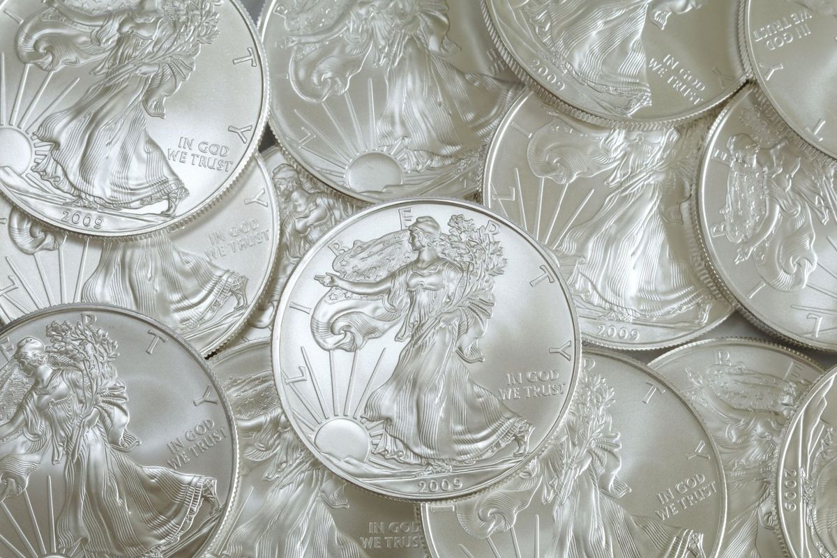 A pile of US silver coins showing Lady Liberty.