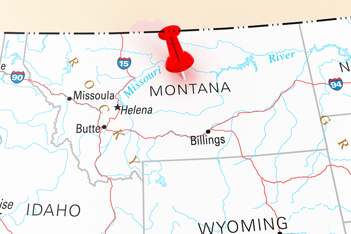 A red pushpin is placed over Montana on a map showing cities and highways.