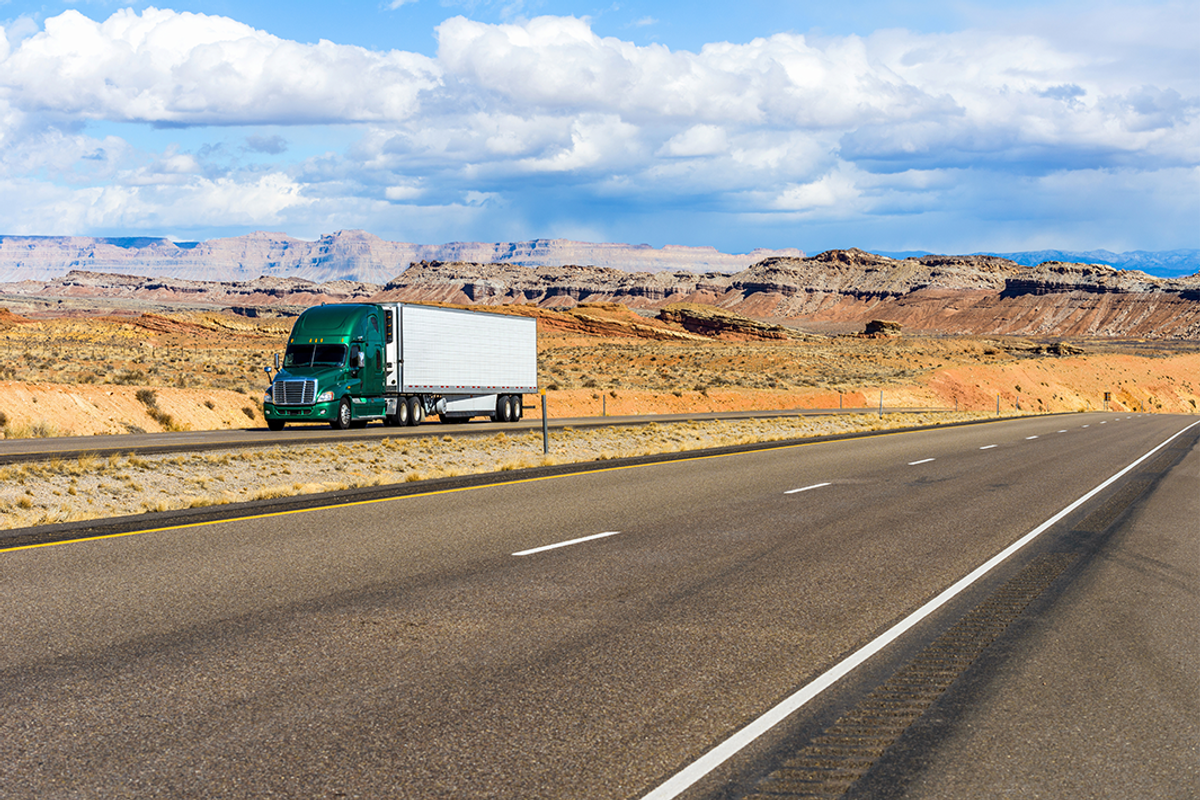 A semi-trailer truck driving on interstate highway.
