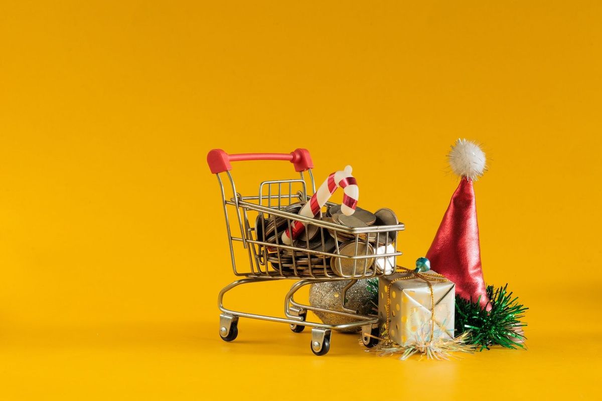 A shopping cart with coins and candy cane.