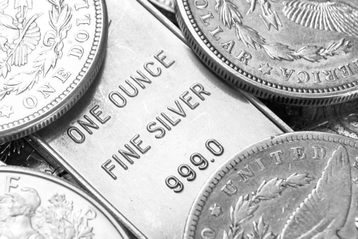 a silver bar beside several silver coins