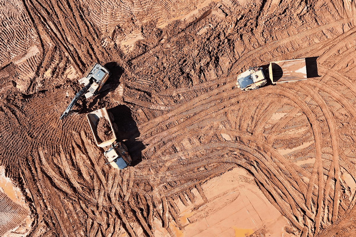 Aerial view of excavators and trucks at a construction site.