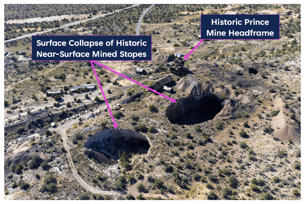 Aerial view of Prince Silver historic mine area with sinkholes and headframe in a desert landscape.