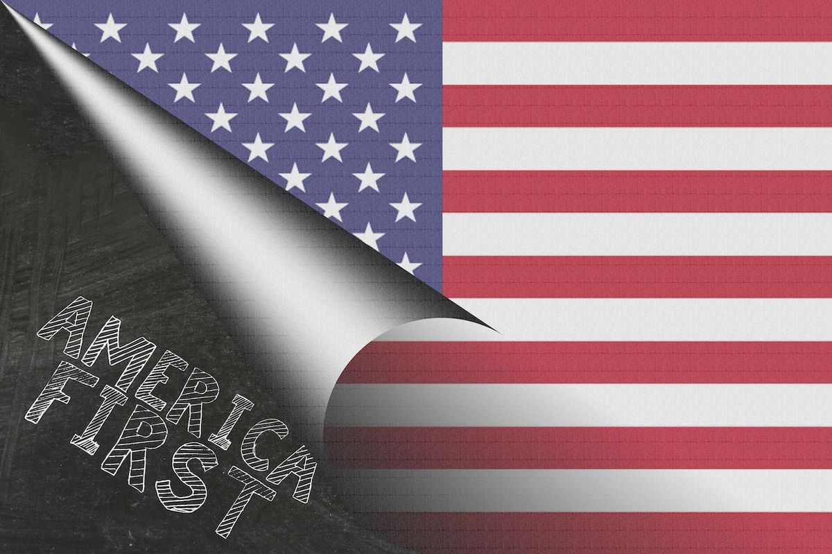 "America First" written on a chalkboard beside US flag.