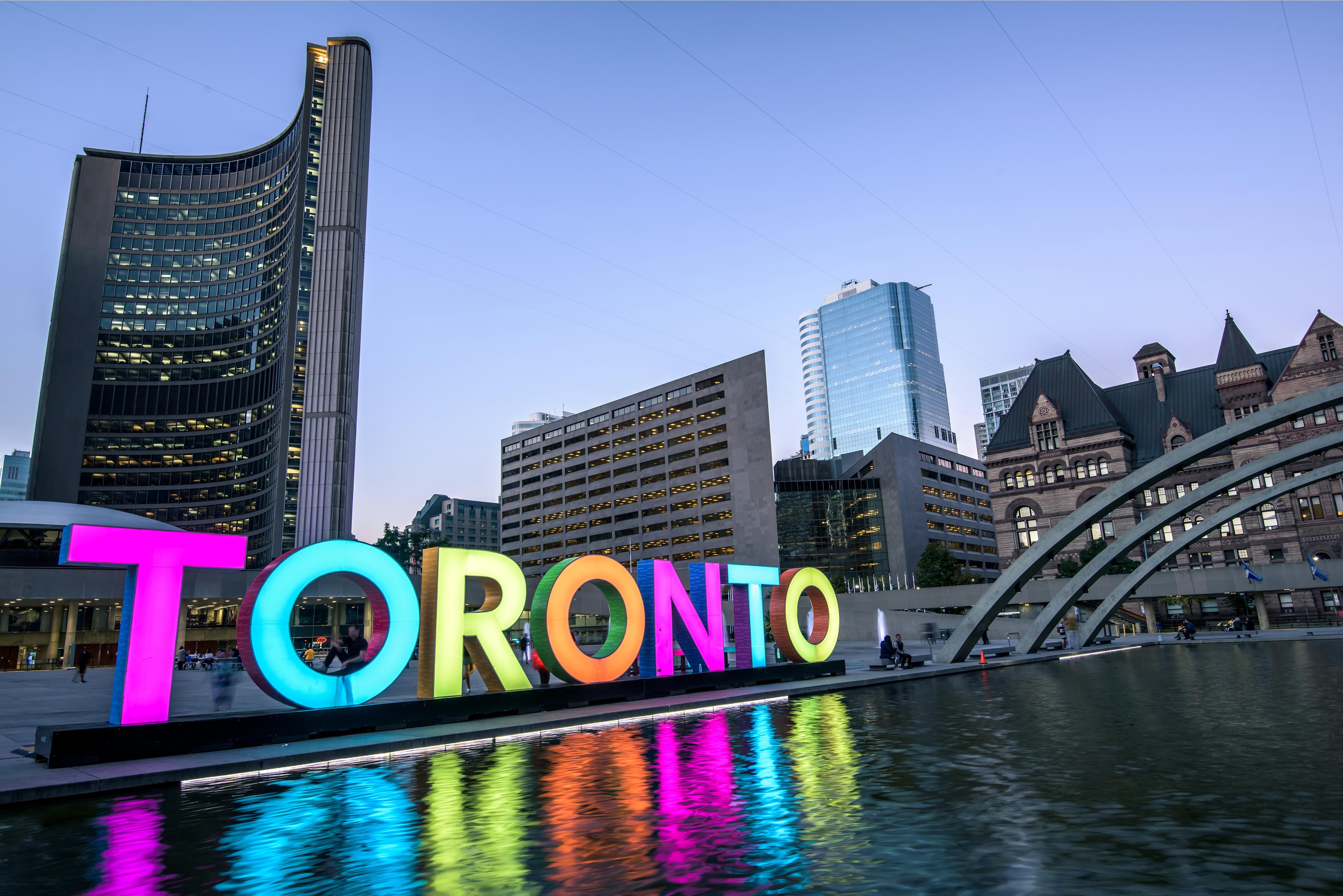 an illuminated TORONTO sign outside Toronto City Hall
