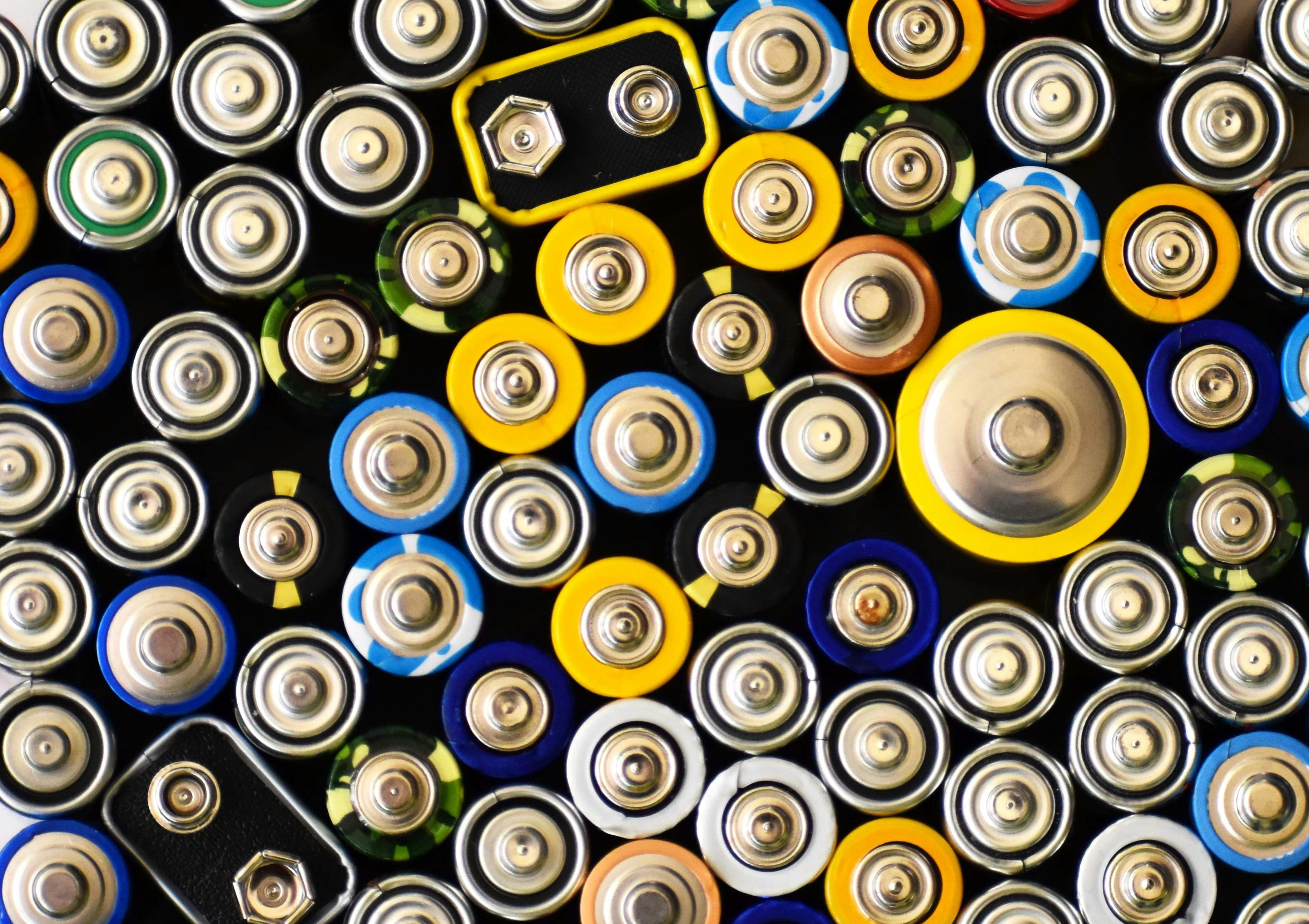 Assorted battery tops in various sizes and colors, arranged closely together.
