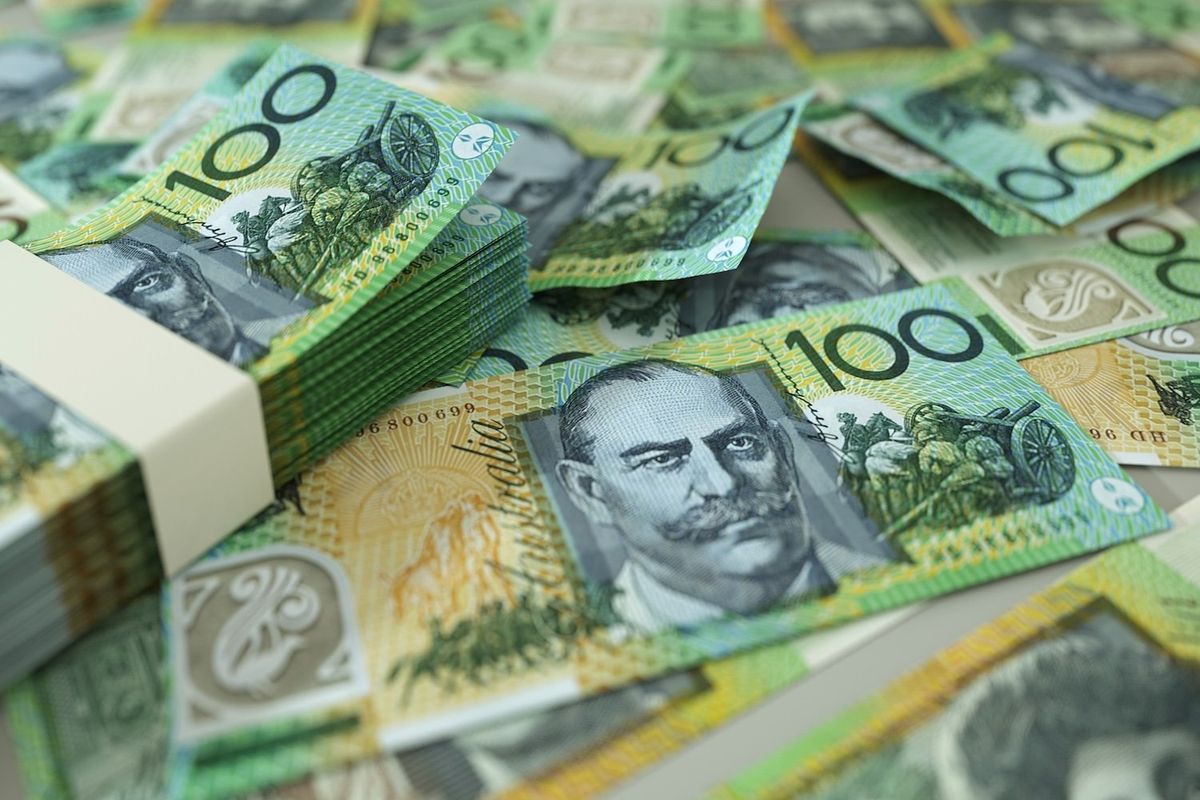 AU$100 notes spread across a table.