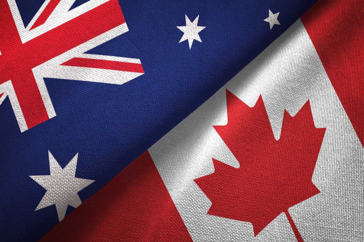 Australia and Canada flags side by side, showing the Union Jack and red maple leaf.