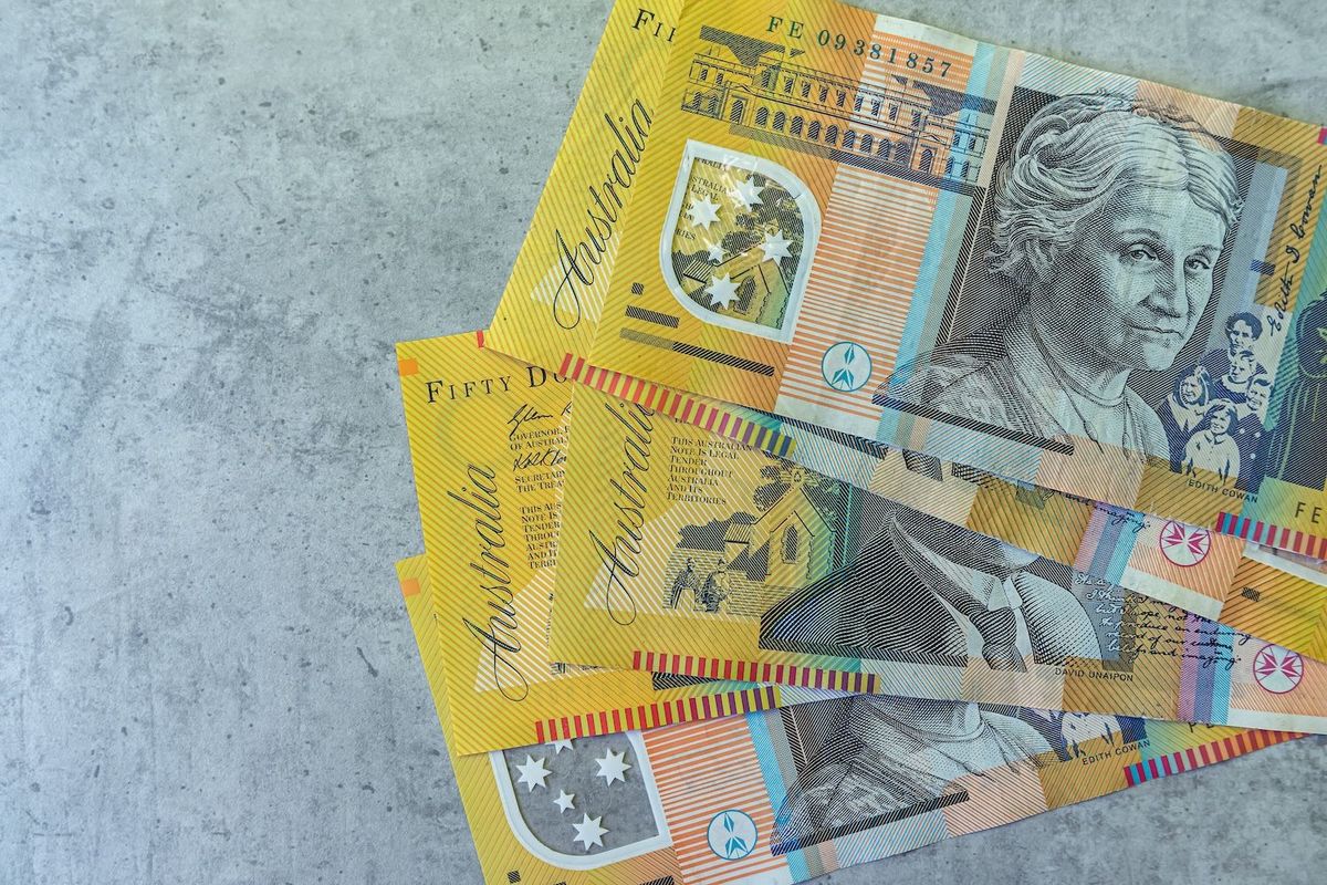 Australian fifty-dollar notes on a concrete surface.