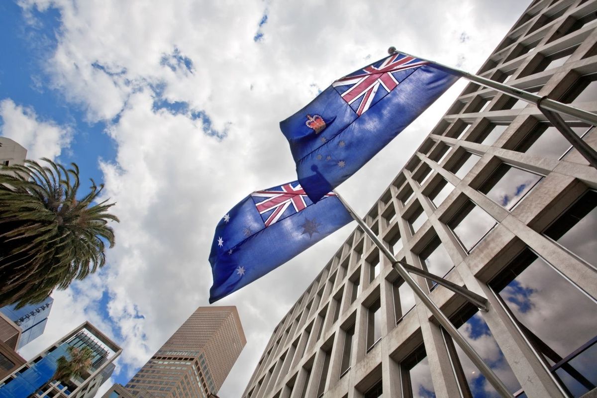 Australian flag and Victoria flag waving on building on a sunny day.