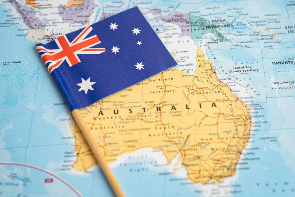 Australian flag pinned on a map of Australia.