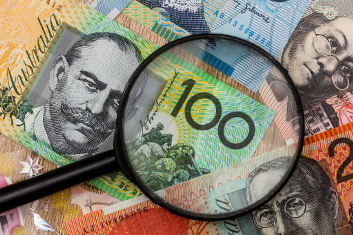 Australian money and magnifying glass.