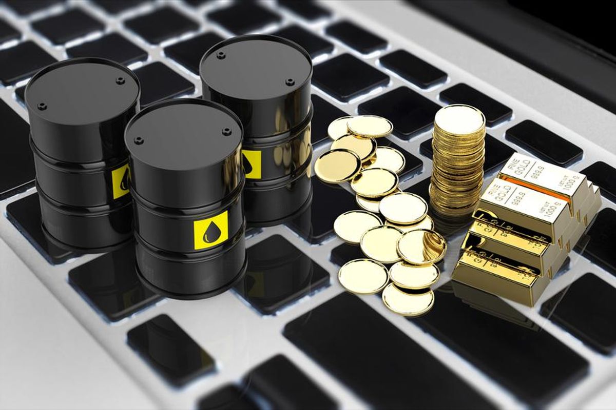barrels of  oil and gold coins on keyboard