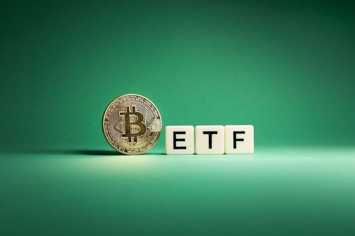 Bitcoin coin beside letter blocks spelling "ETF" on a green background.