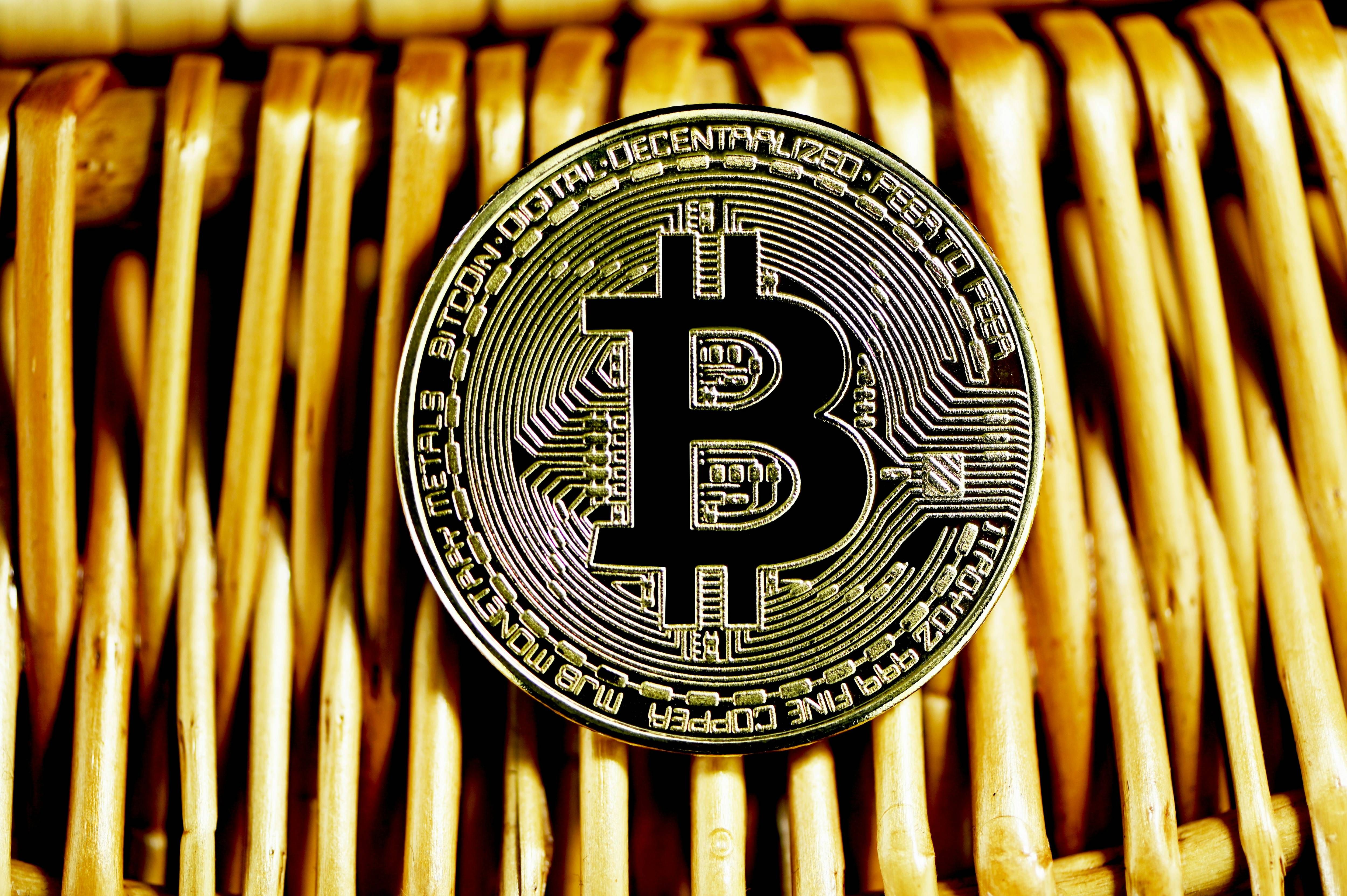 Bitcoin coin on a woven wicker surface, close-up view.