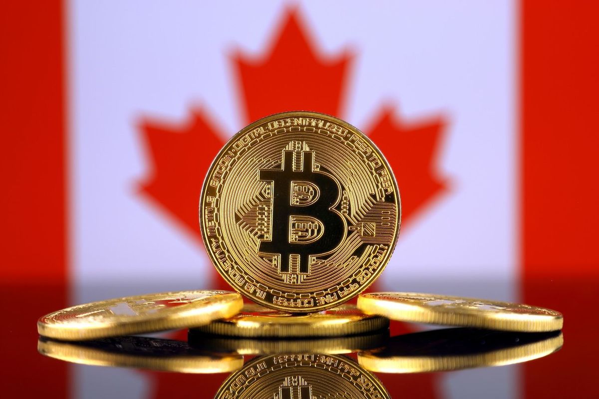 Bitcoin coins in front of a blurred Canadian flag background.