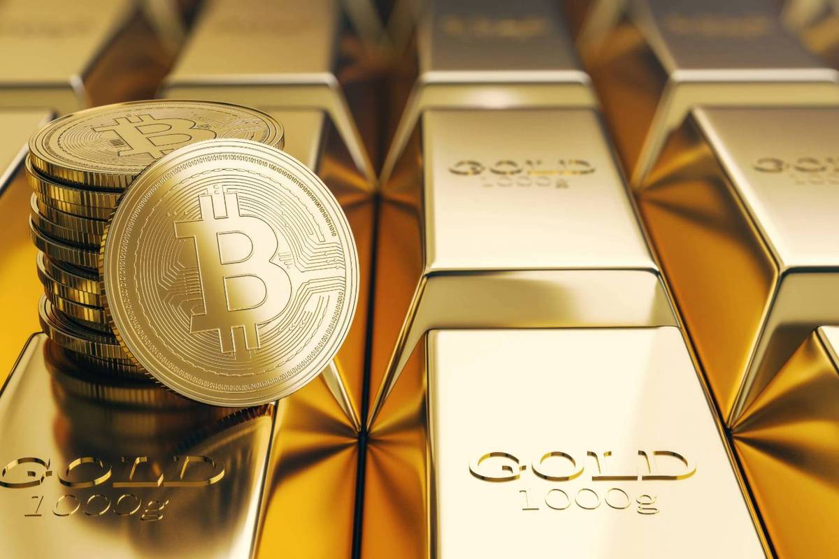 Bitcoin coins stacked on gold bars.