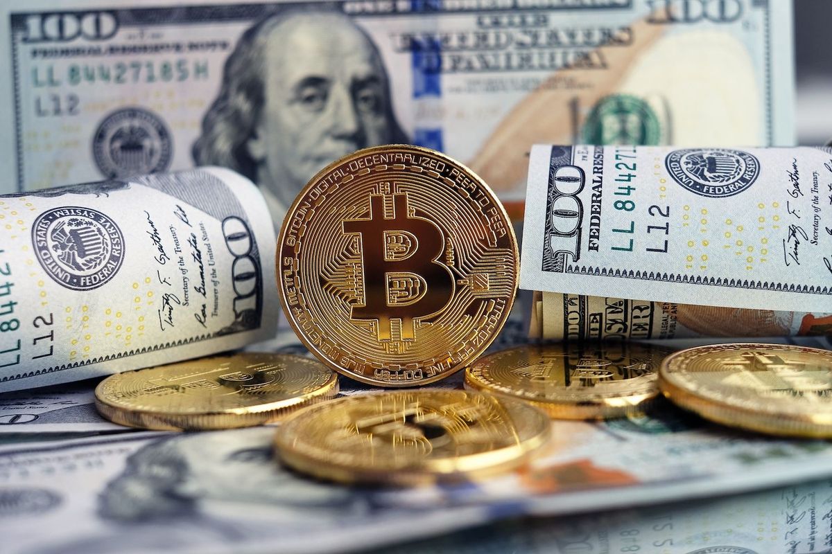 Bitcoin coins stacked on US dollar bills, symbolizing cryptocurrency and currency exchange.