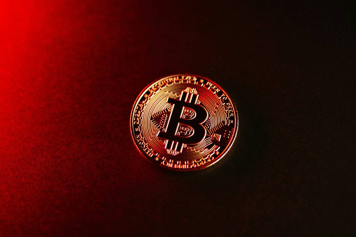 Bitcoin on a dark surface with red lighting.