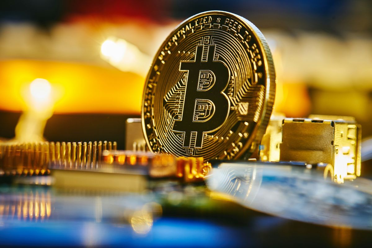 Bitcoin on circuit board with glowing lights.