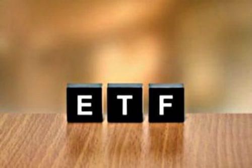 black blocks spelling "ETF" on a brown desk