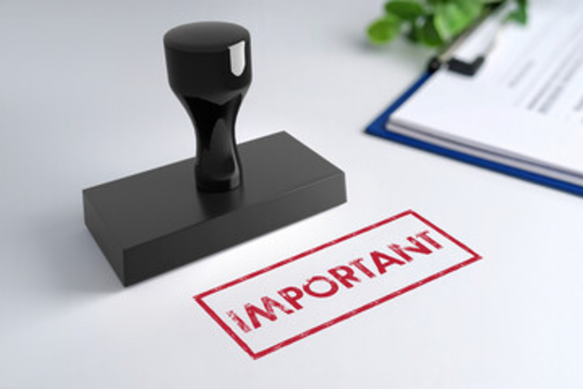 Black stamp with word "important" in red next to clipboard on desk.