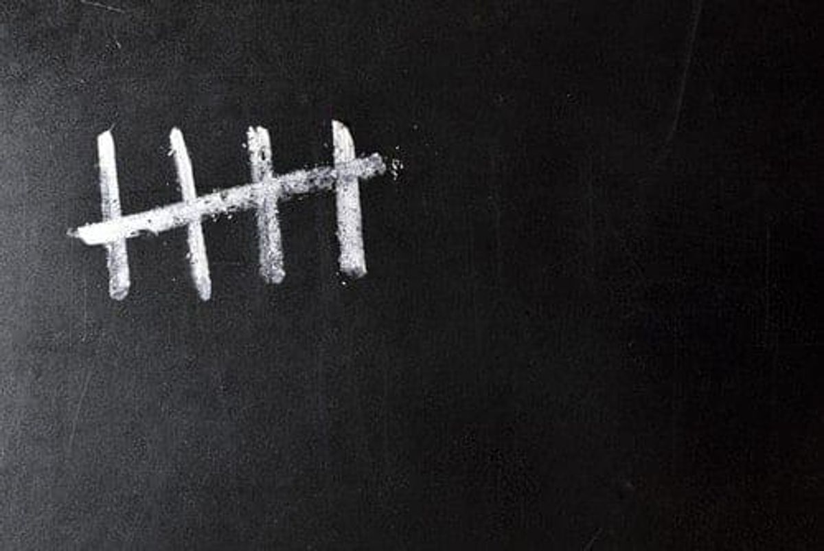 blackboard with five chalk tally marks