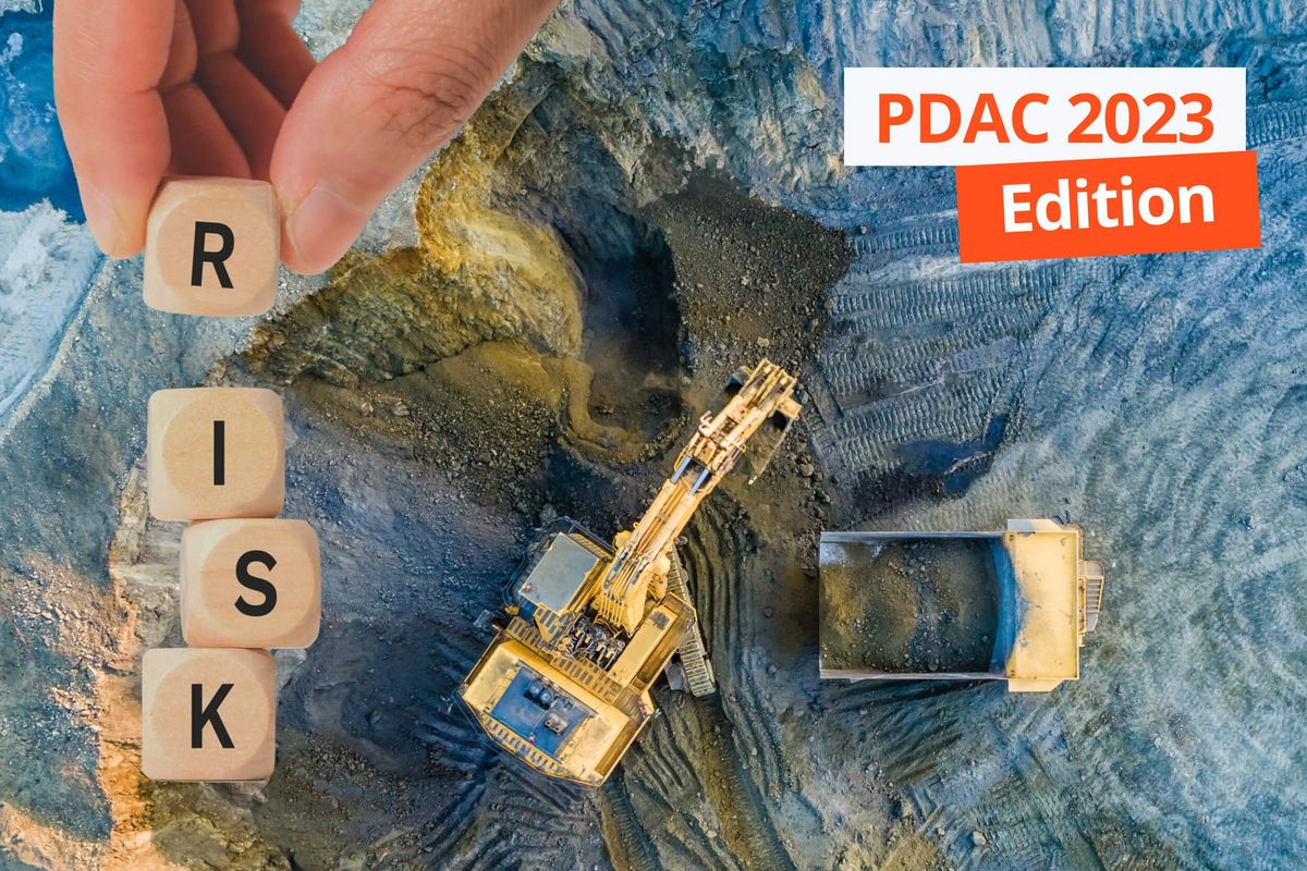 blocks spelling "RISK" with trucks at mine site