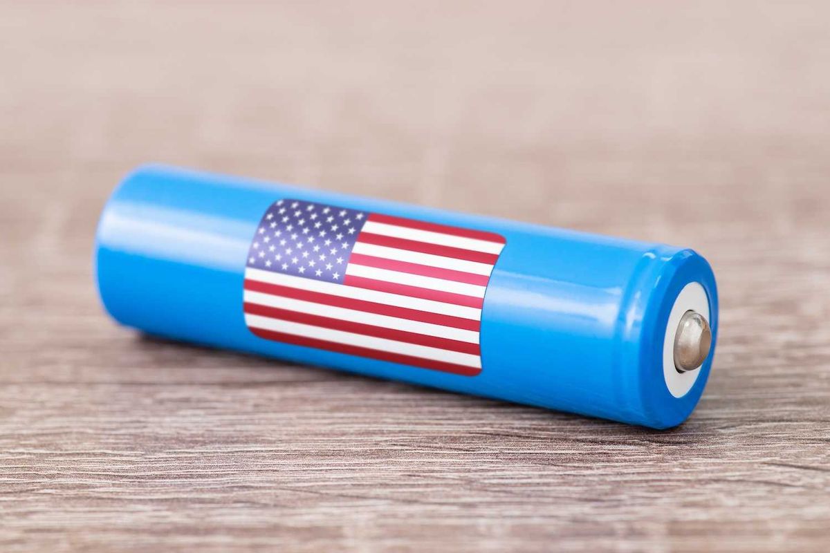 Blue battery with a US flag decal on a wooden surface.