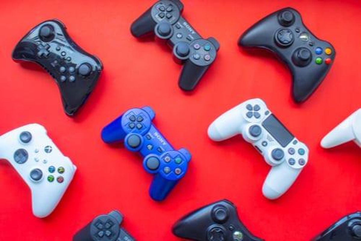 blue, black and white game controllers on a red background