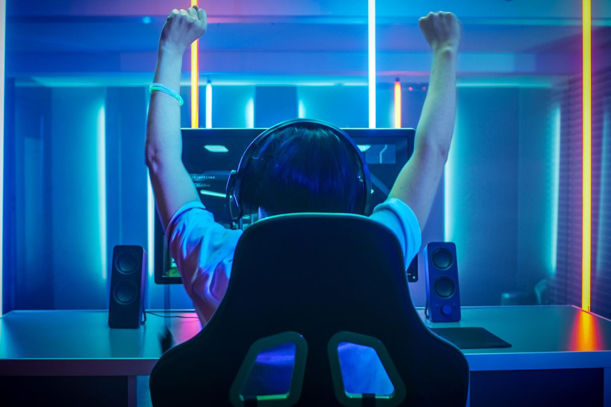 boy playing video game with hands up