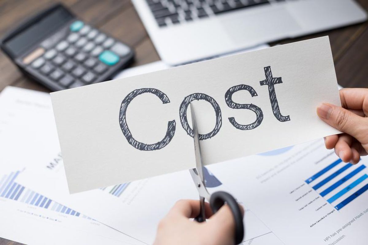 business person cutting a cost sign