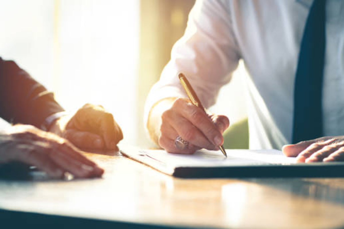 Businessman signs paper.