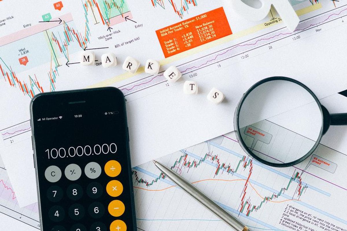 calculator with stock charts and magnifying glass