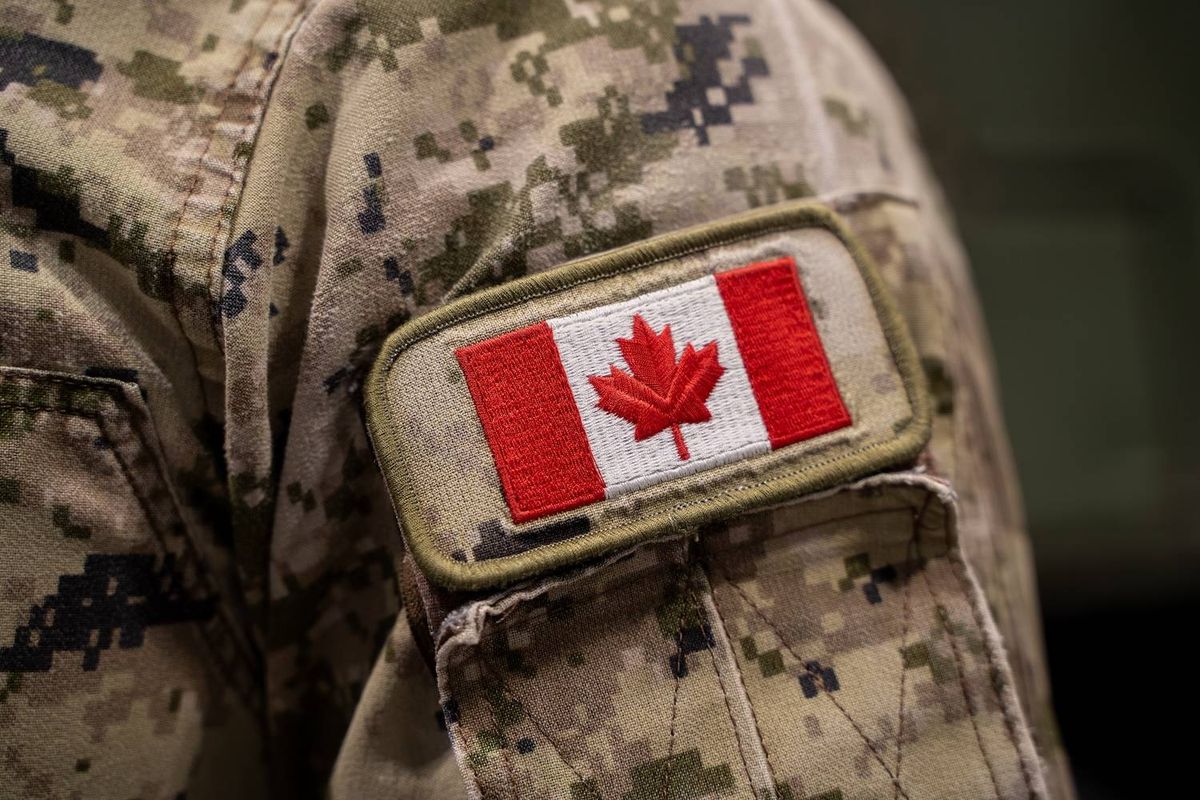 Canadian flag patch on a camouflage military uniform sleeve with digital pattern.