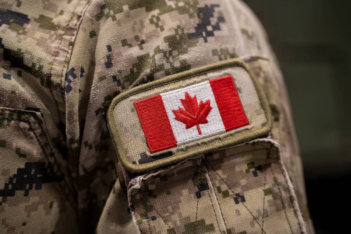 Canadian flag patch on a camouflage military uniform sleeve with digital pattern.