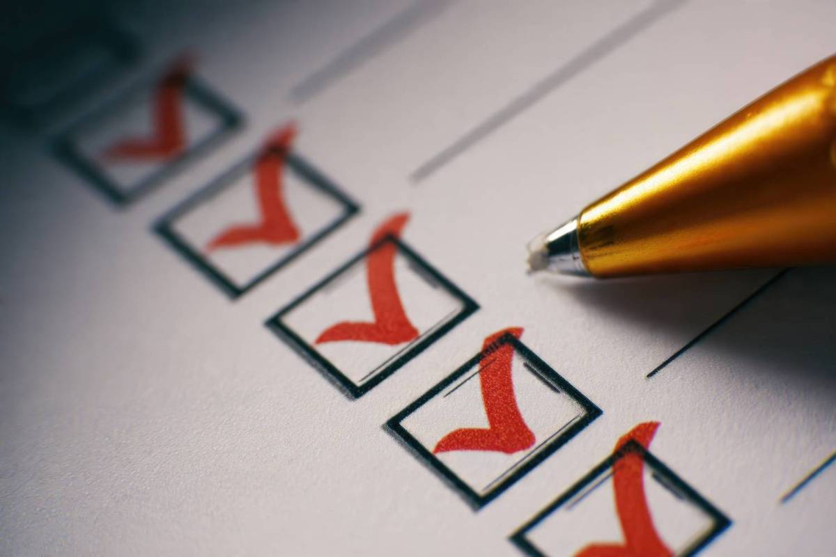 Checklist with red check marks and an orange pen.