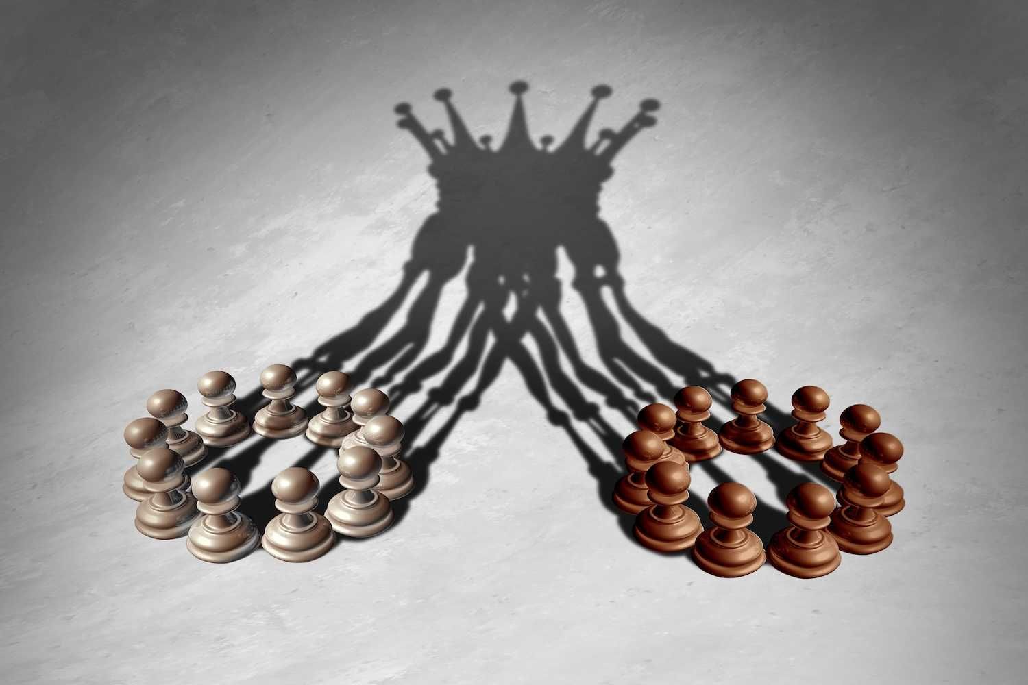 Chess pawns casting a shadow resembling chess kings on a textured surface.