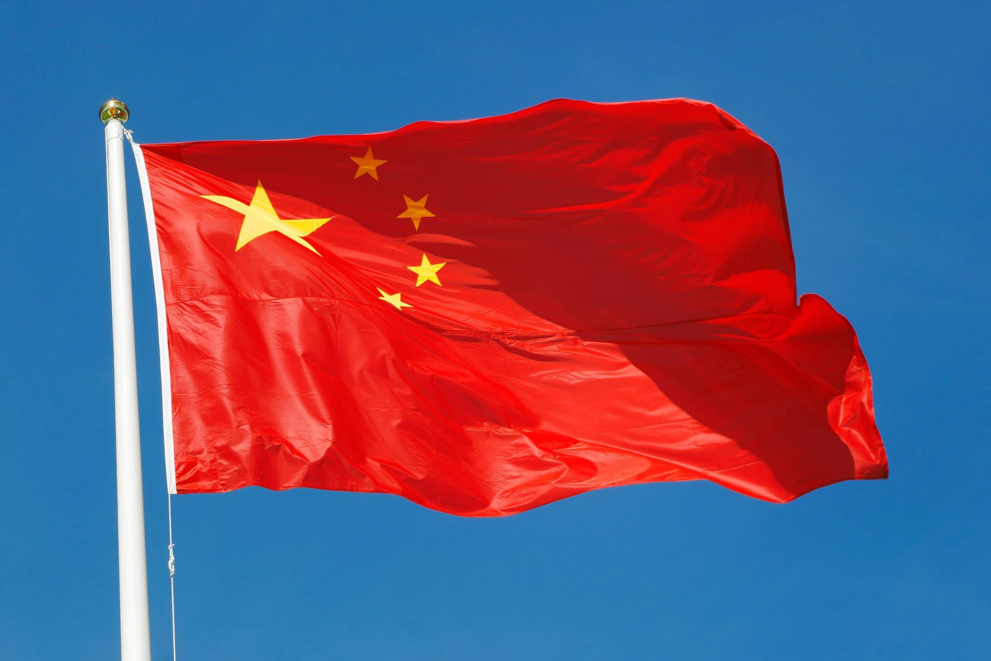 China flag waving against a clear blue sky.