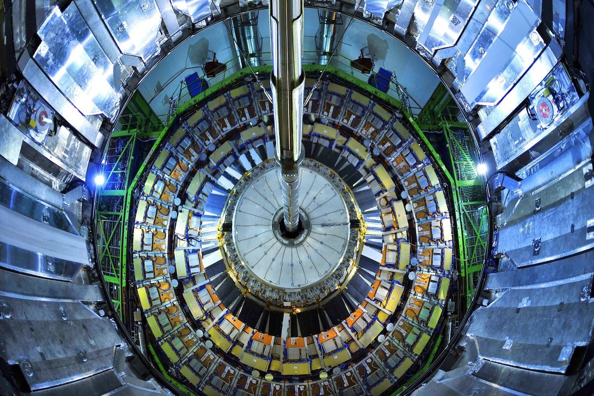 Circular interior view of a particle accelerator, showcasing intricate machinery and lights.