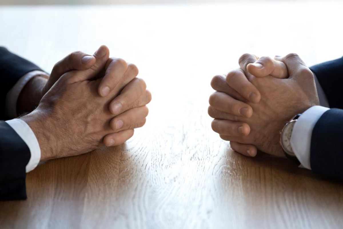 clasped business hands facing off