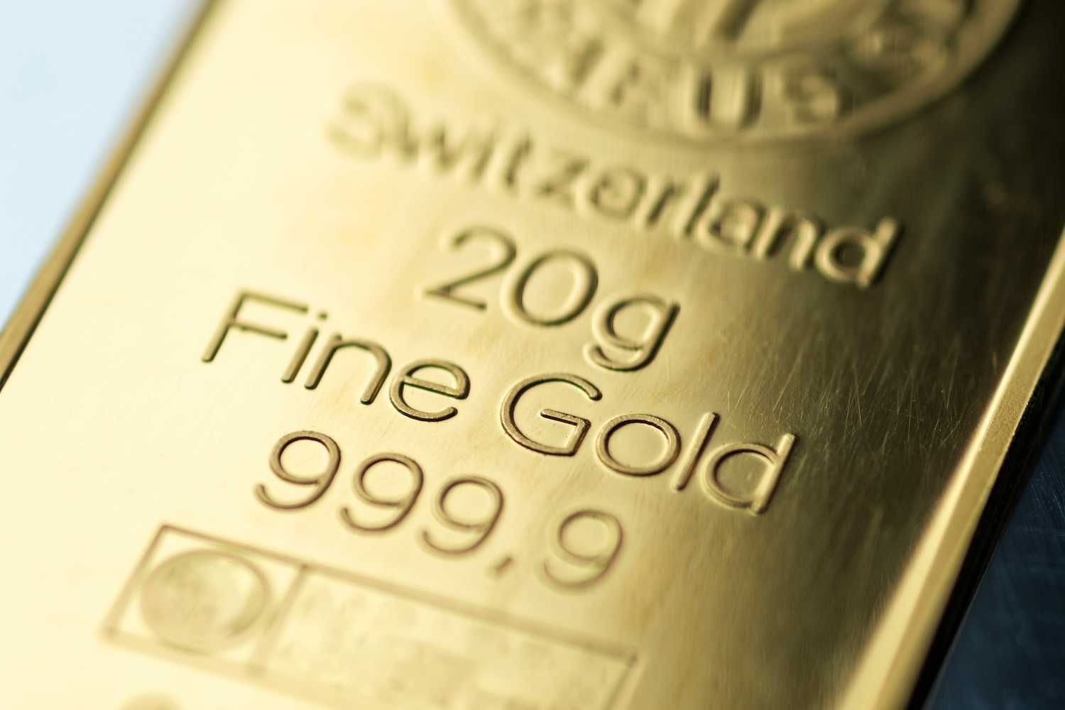 Close-up of a gold bar with "20g Fine Gold 999.9" inscribed on it.