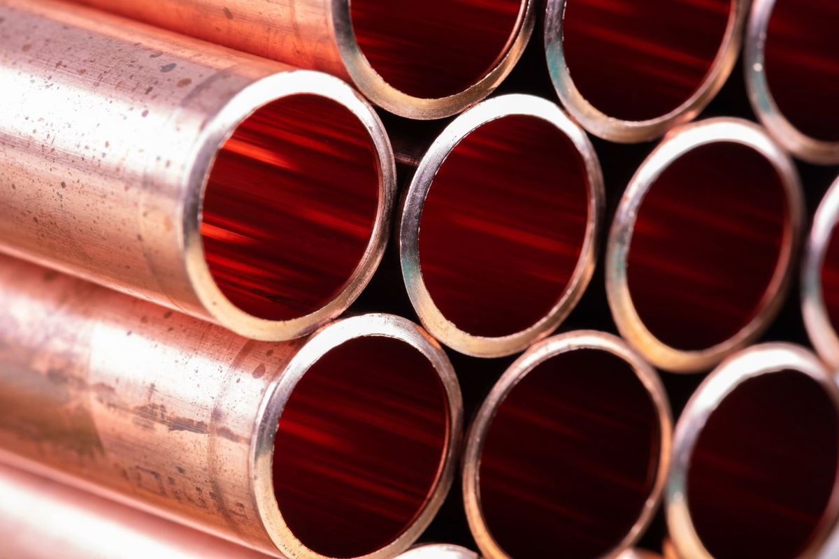 Close-up of stacked copper pipes with hollow circular openings.